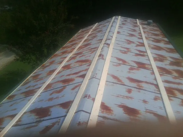Rusted metal roof panels with new wood purlins before replacement — Storm Damage Roof Repair in Plato by Roofing Brothers