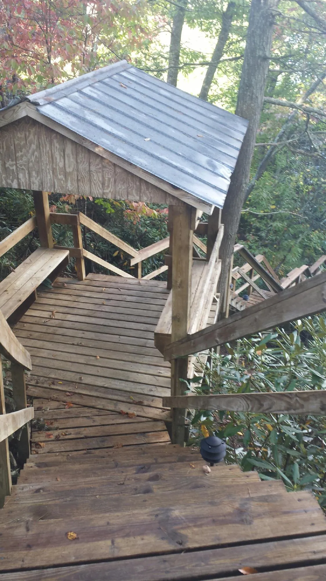 Metal roofed shelter over wooden steps on a wooded walkway — Skylight Repair & Installation work by our crew in Plato